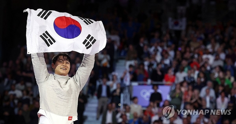 남자 사브르 개인전에서 금메달을 딴 뒤 태국기를 들고 기뻐하는 오상욱 한국대표팀 펜싱 선수. 
